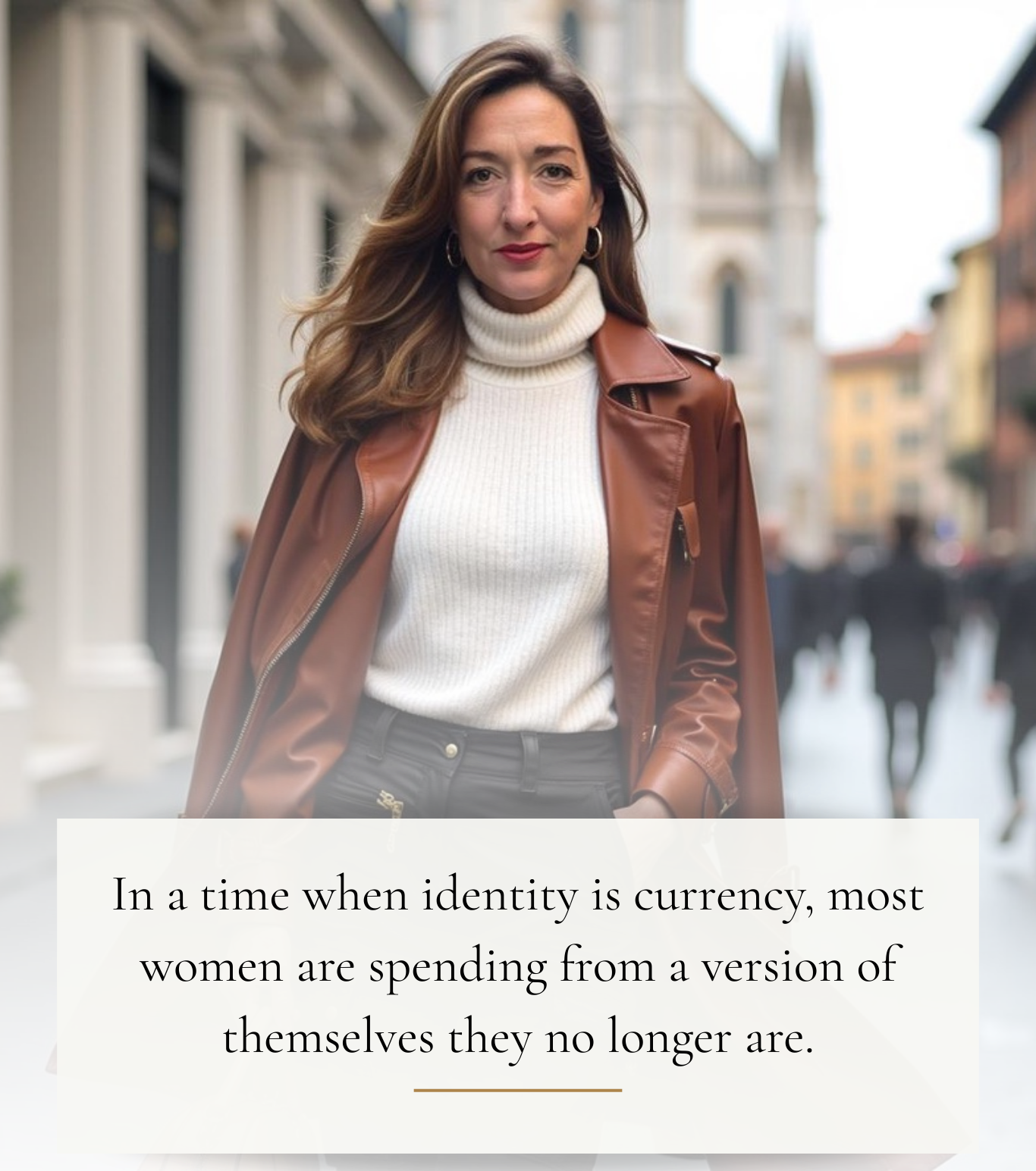 A woman with long brown hair, wearing gold hoop earrings, a white turtleneck, and a brown leather jacket, walking outdoors in an urban setting with historic buildings in the background.