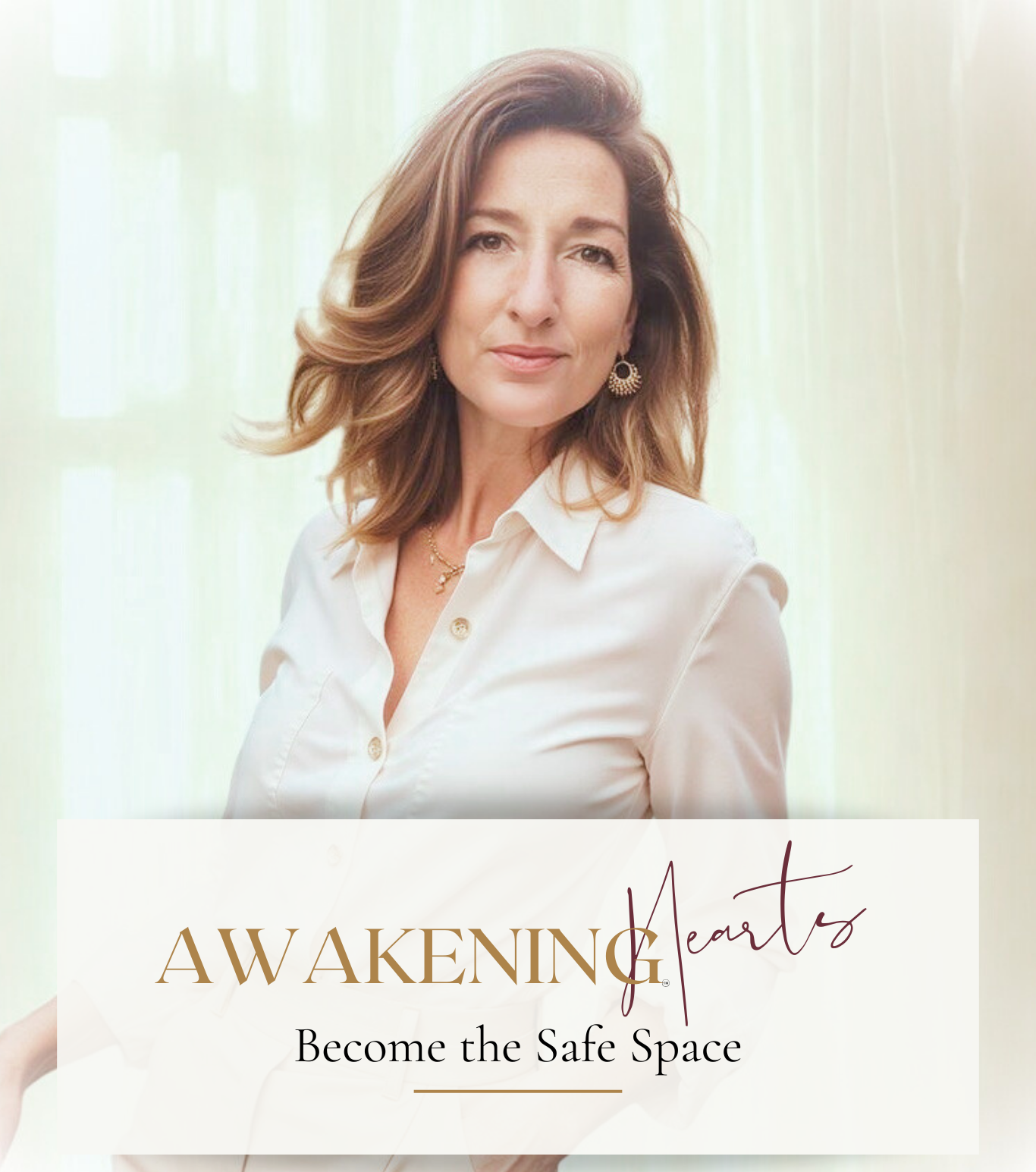 A woman with shoulder-length brown hair, wearing a white button-up shirt and gold earrings, standing in front of a soft-colored background with sheer curtains.