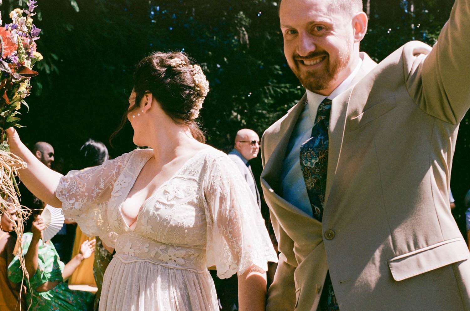 couple celebrating getting married walking down the aisle with hands raised