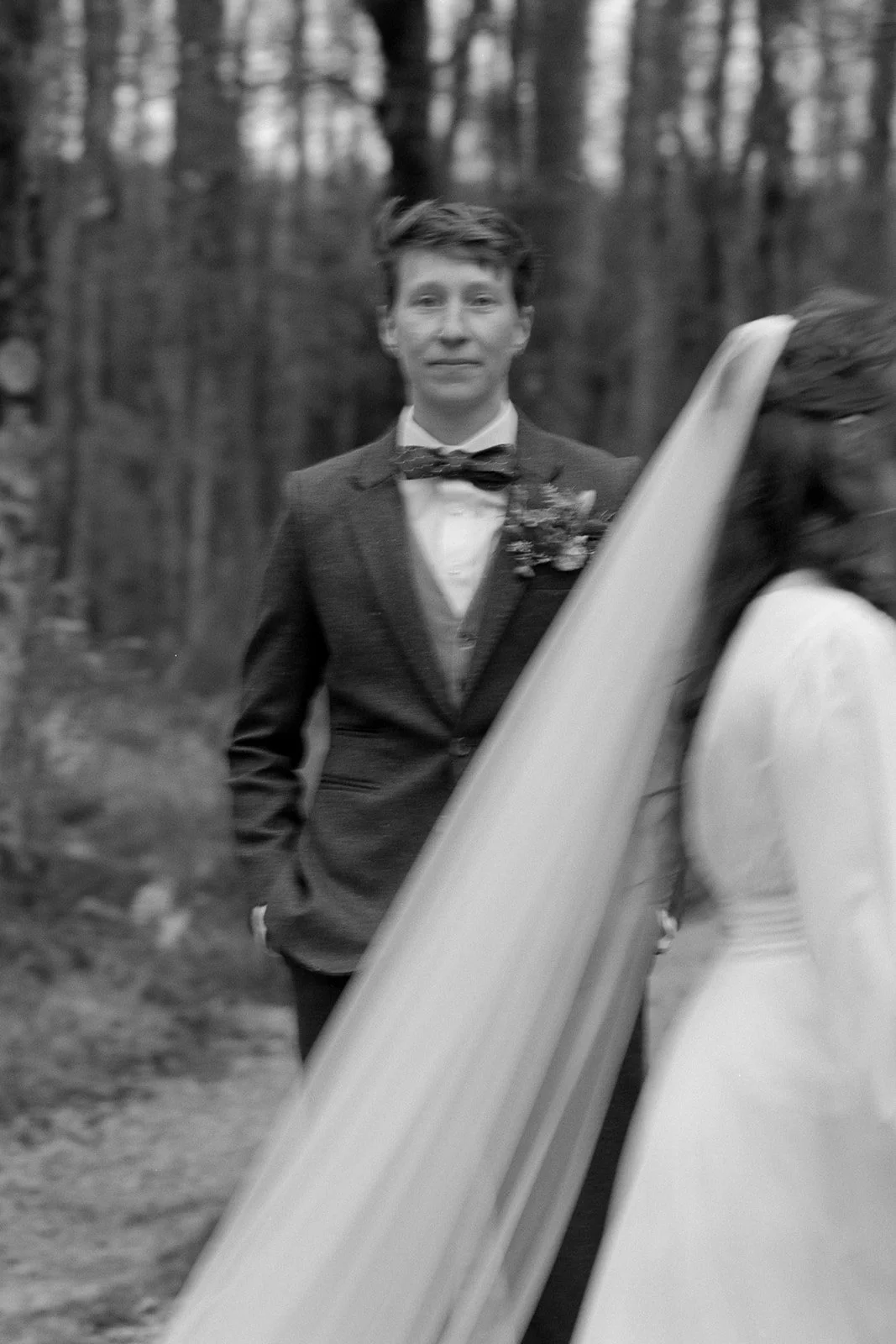 black and white photo of a couple portrait in the forest with the blue ridge mountains in the background