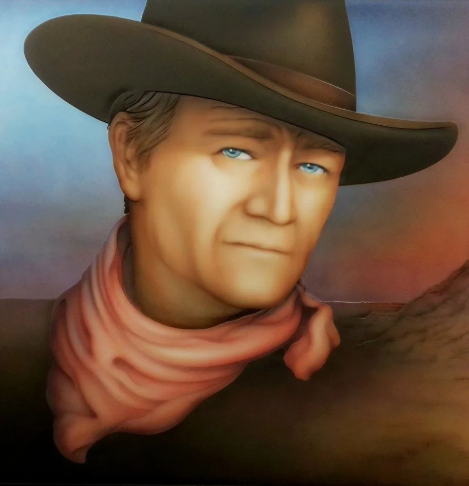 Carved and painted mirror, John Wayne with blue eyes wearing a cowboy hat and a bandana around his neck.