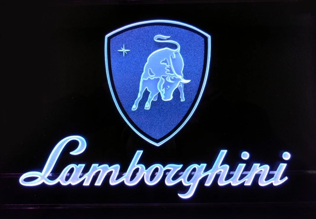 Edge lit glass sign with Lamborghini logo showing a shield with a bull and the word Lamborghini written below.