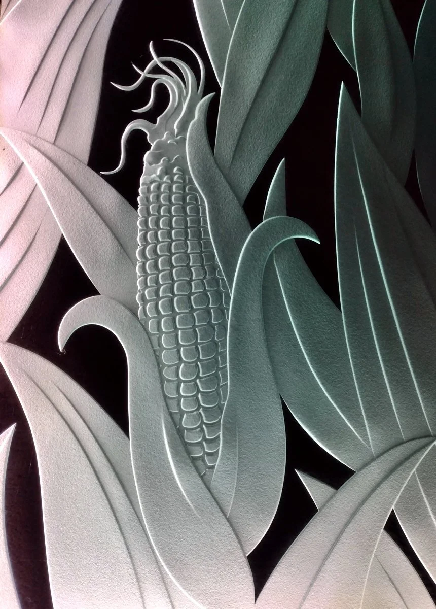 Carved glass wall panel featuring a corn stalk with leaves.