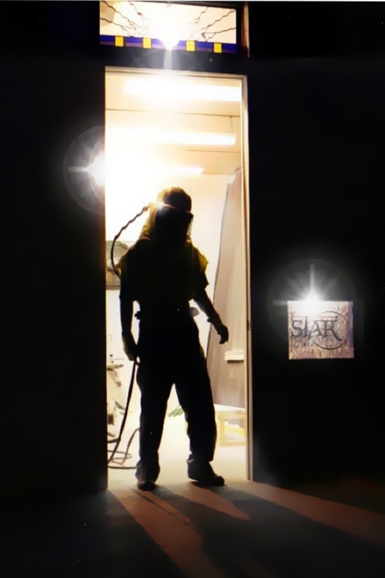 man in sandblasting suit at booth door