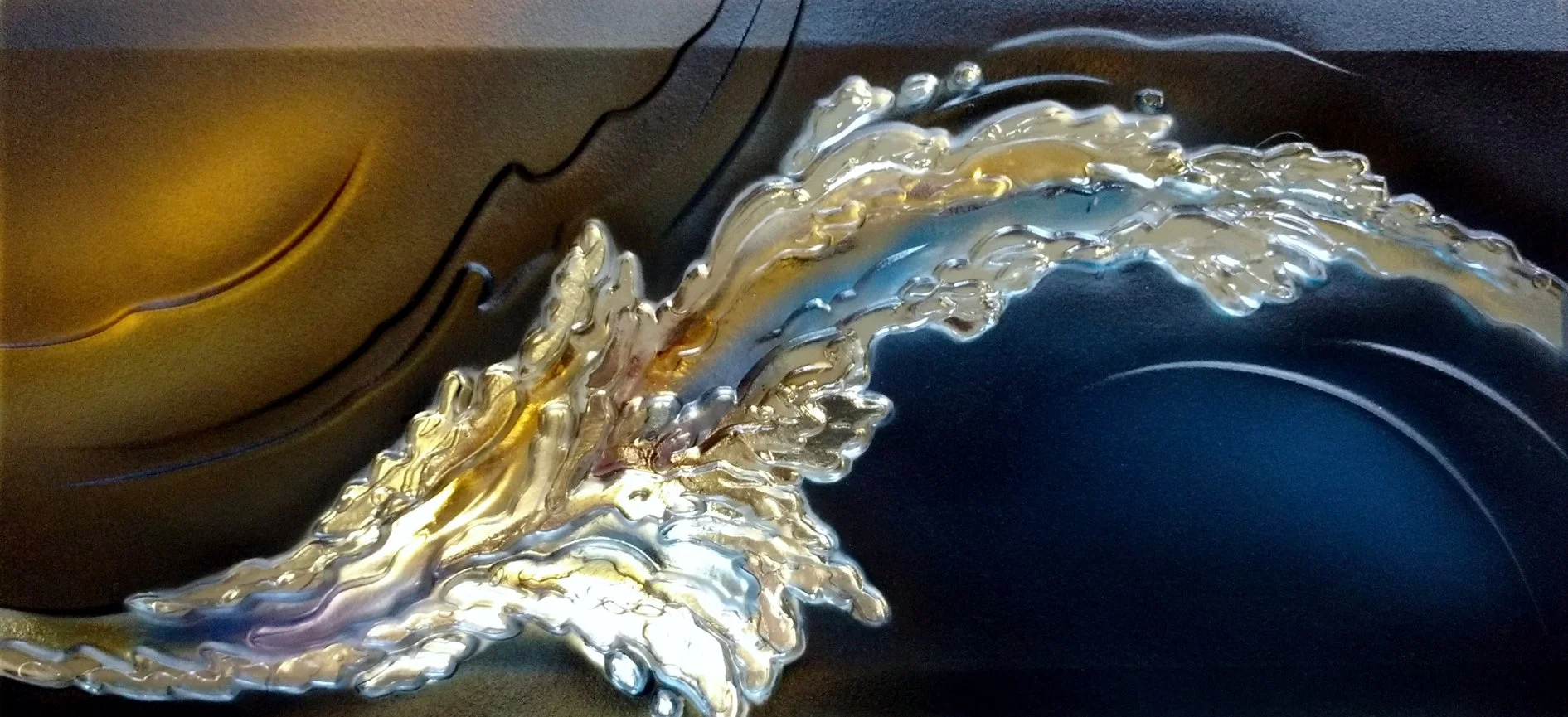 Abstract artwork with metallic, shiny textures resembling a flowing wave or ribbon in silver, gold, blue, and black colors.