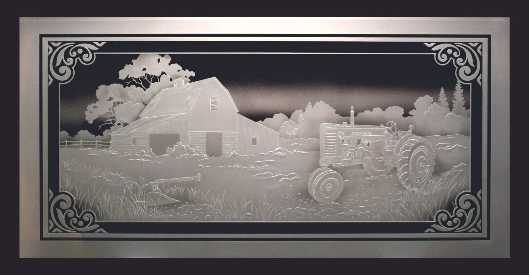 A carved glass display of a rural farm scene featuring a barn, a John Deere tractor, trees, and clouds, with ornate borders.