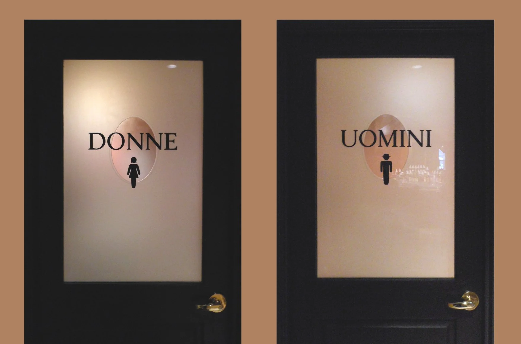 Two carved and painted bathroom doors: the left one labeled 'DONNE' with a female icon, and the right one labeled 'UOMINI' with a male icon.