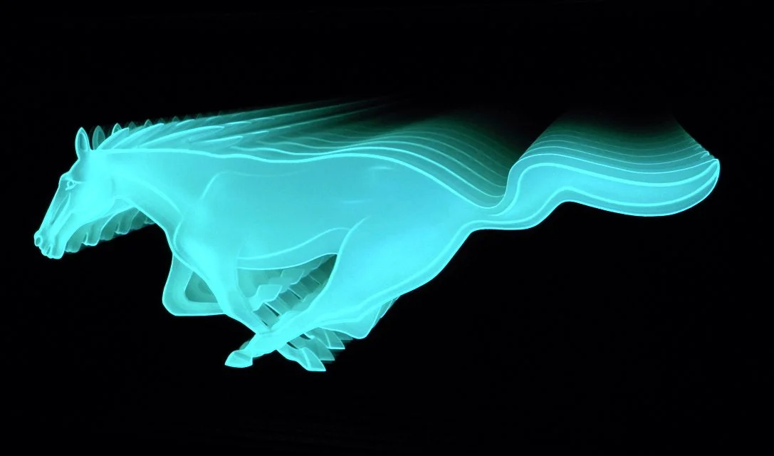 A glowing, edge lit glass sign of a Mustang.