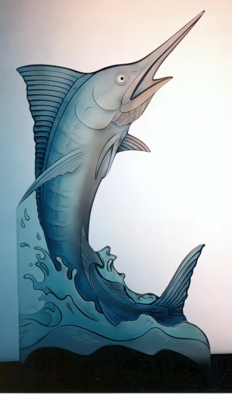 A mural of a marlin fish jumping out of the water, depicted in shades of blue and gray with stylized waves at the bottom.