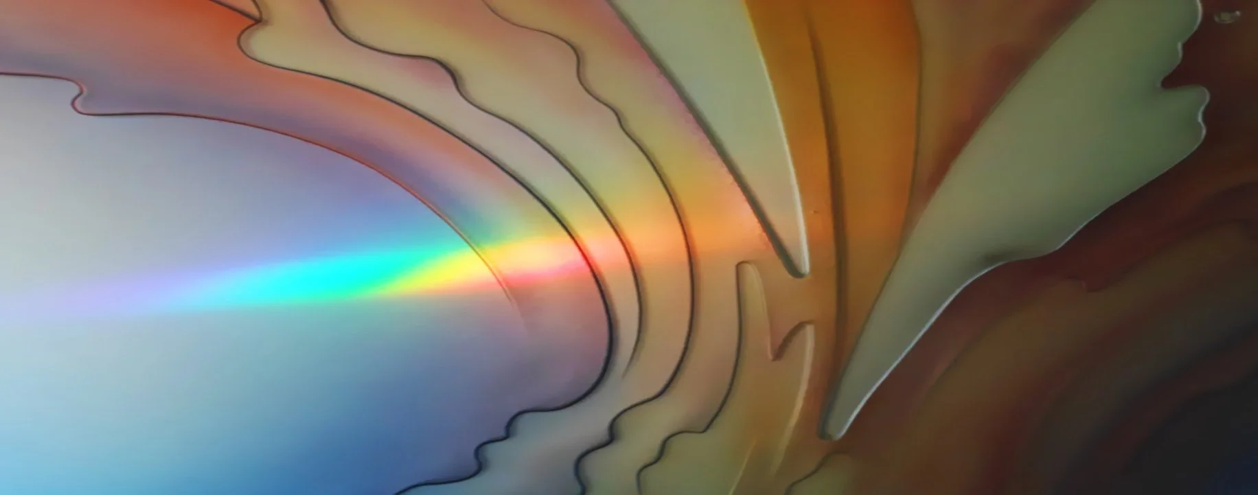 Close-up of a rainbow prism creating colorful reflections on a carved glass art surface.