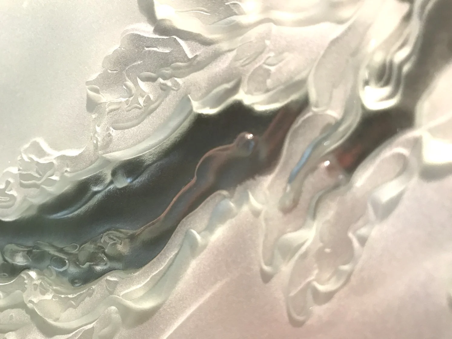 Close-up of a silver coin with detailed engravings, showing a profile of a person's face and decorative elements.