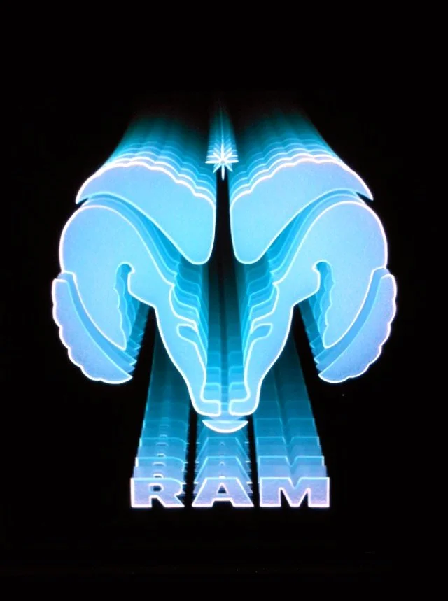 Edge lit glass sign of RAM logo with blue lights and the word 'RAM' underneath.