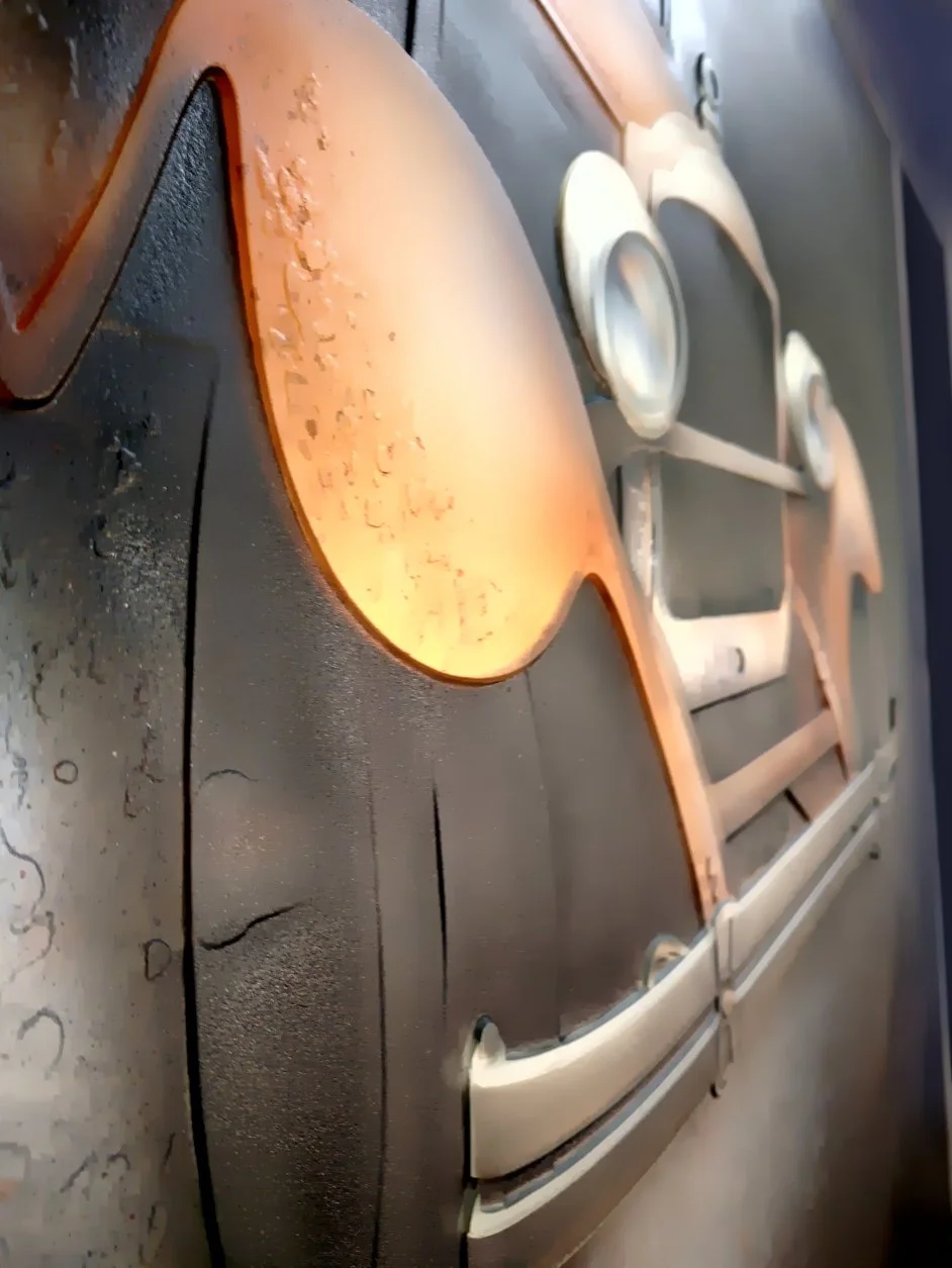 A metallic oven door with a window, two round knobs, and a handle, showing a slightly burnt and greasy surface, with dust and marks on the surrounding countertop.