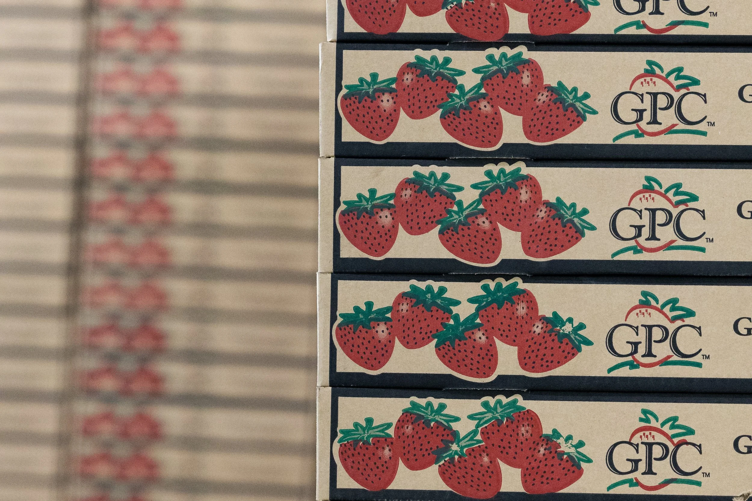 Stacked boxes of strawberries with the GPC brand logo on each box.