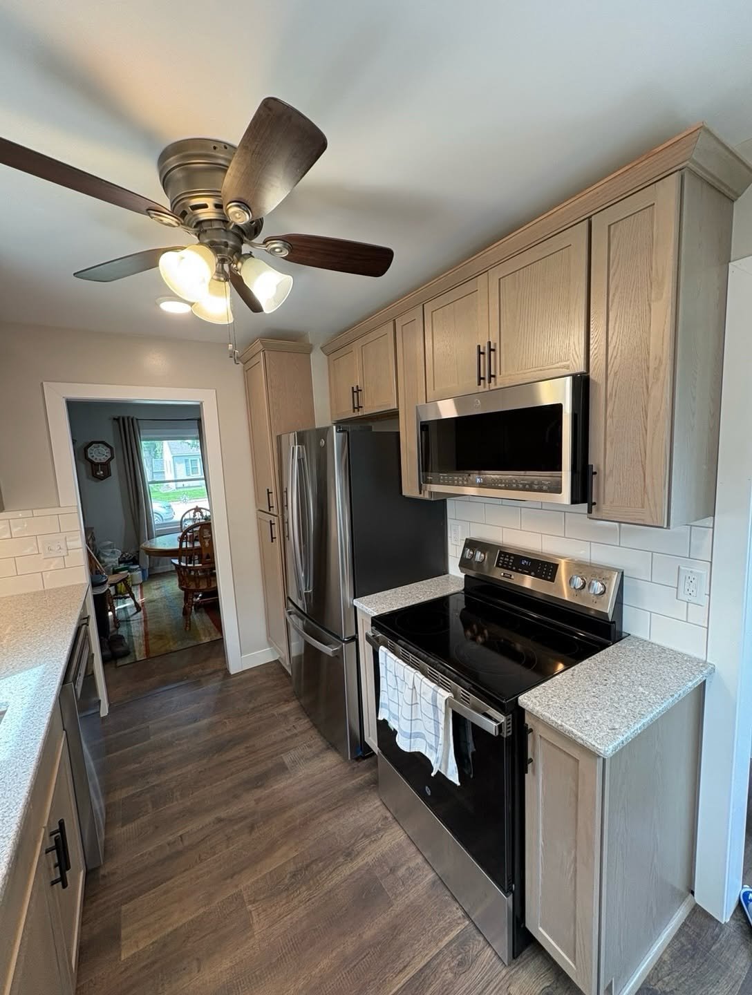 Kitchen remodel cooking area with a range, range hood, and surrounding cabinets