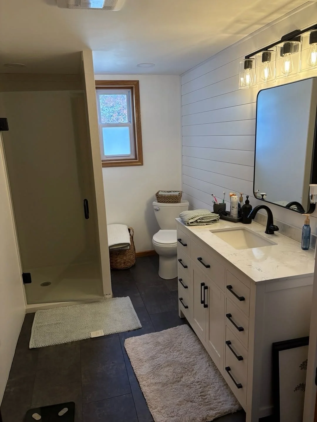 Updated bathroom with a white vanity, round mirror, and blue walls