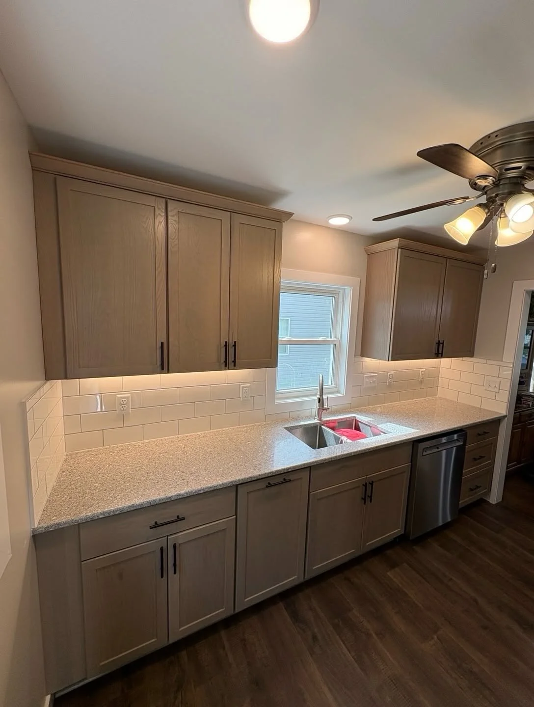 Remodeled kitchen with a sink below the window and surrounding cabinetry