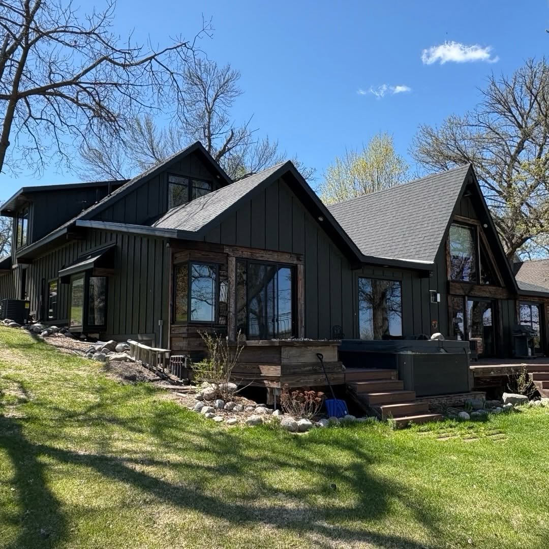 Angled view of the completed home, showing multiple gables, windows, and deck steps.