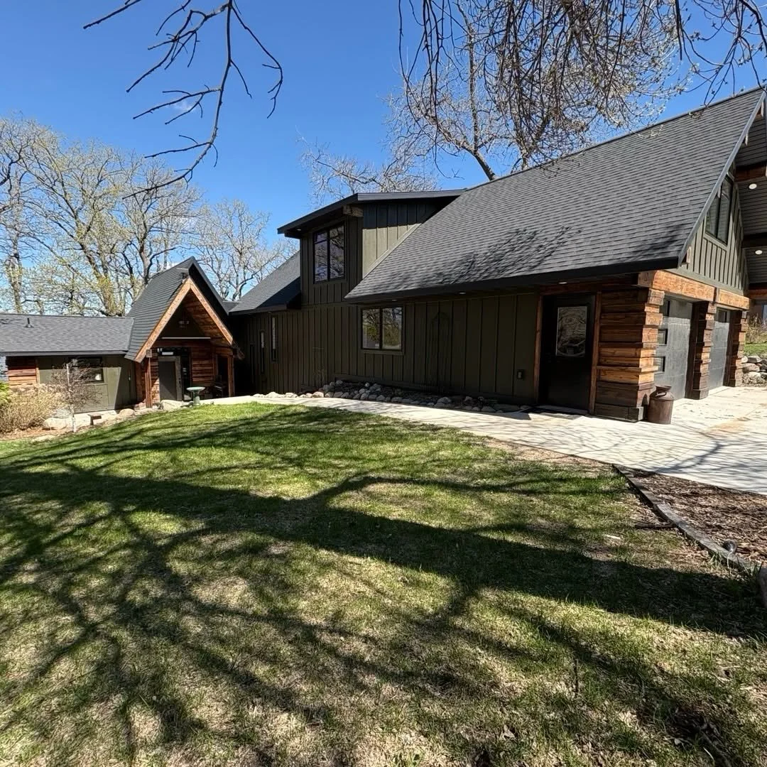 Side view of the completed home, showing the roofline, windows, and covered entry.