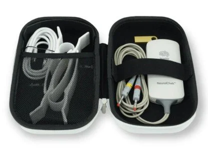 Open small black carrying case containing various electronic devices and cables, including a power adapter, charging cables, and connectors.