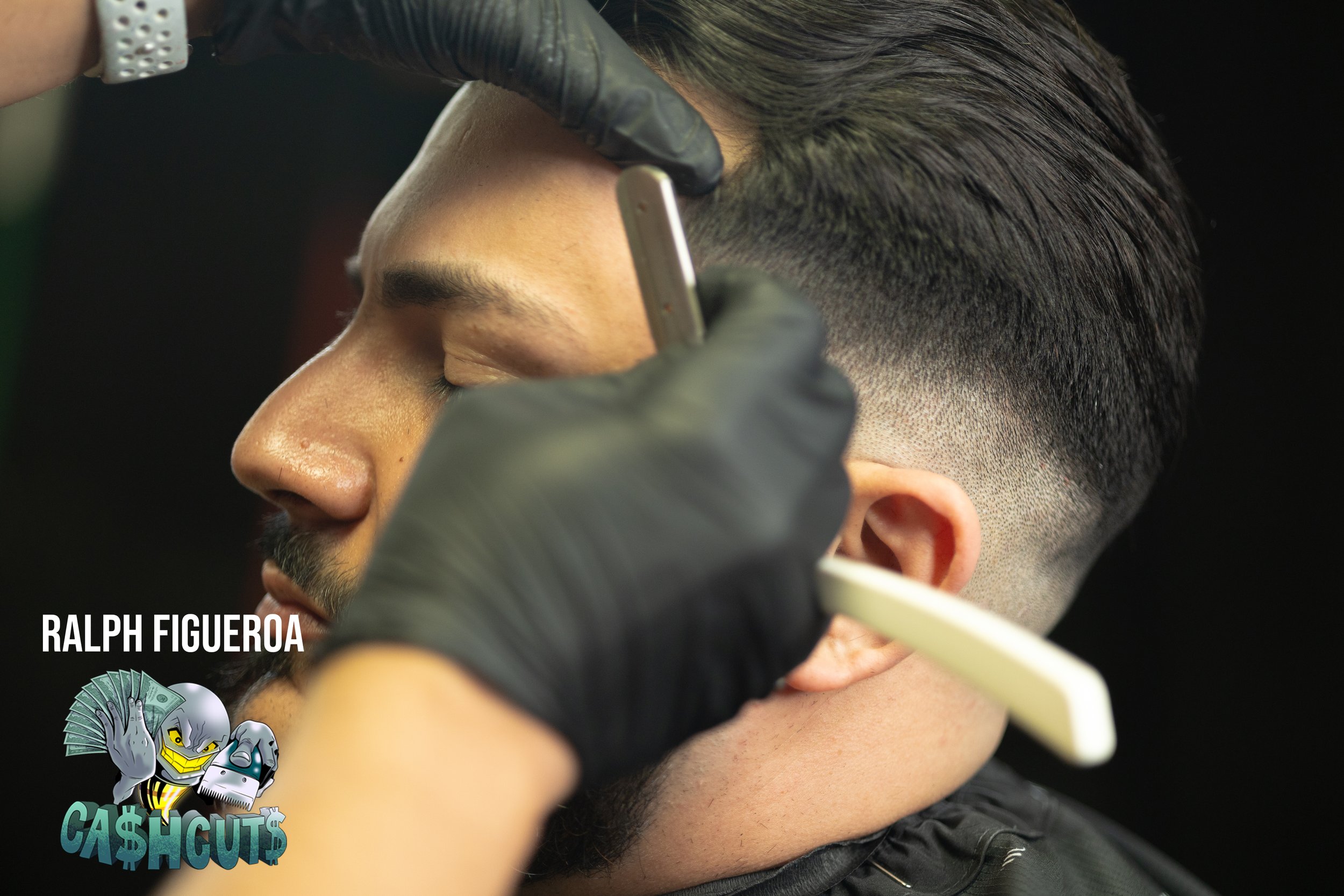 A man getting a close shave at a barber shop, with barber using an electric razor on his face and holding a straight razor in hand. The barber wears gloves and the scene is professional.