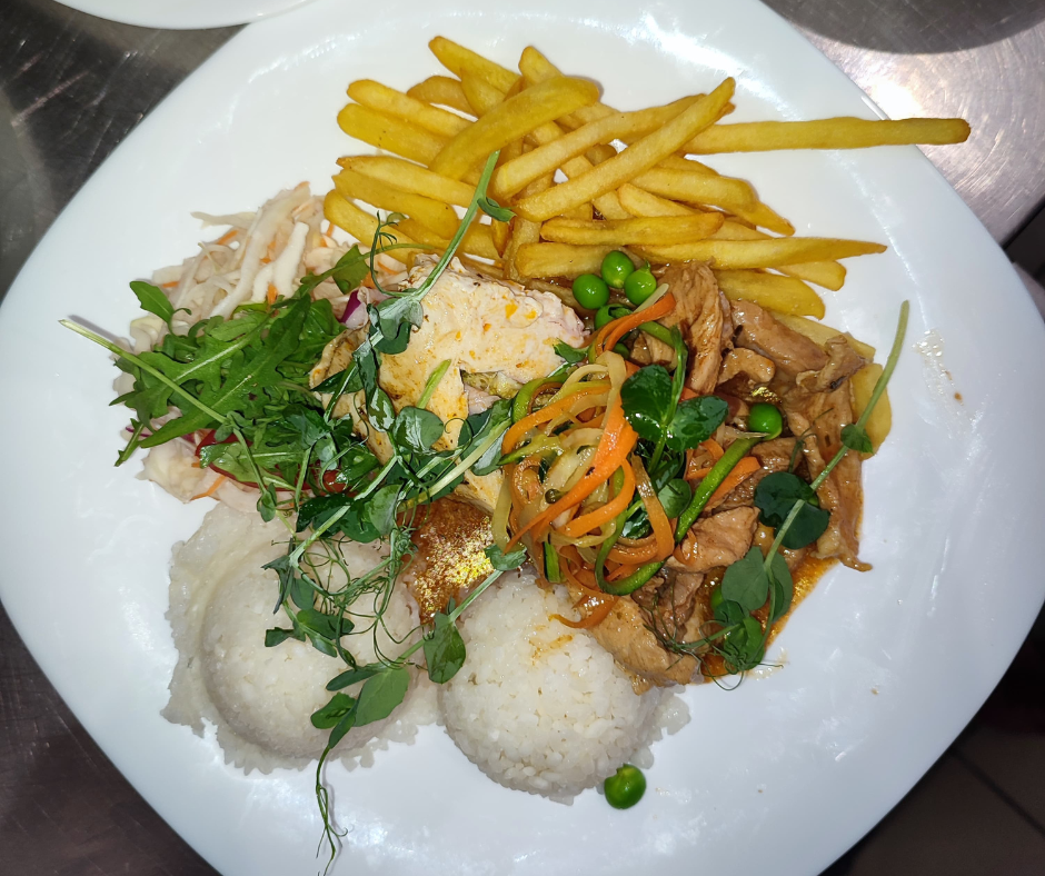 Plate with French fries, green peas, shredded meat with vegetables, mashed potatoes, and a salad with greens and shredded vegetables.