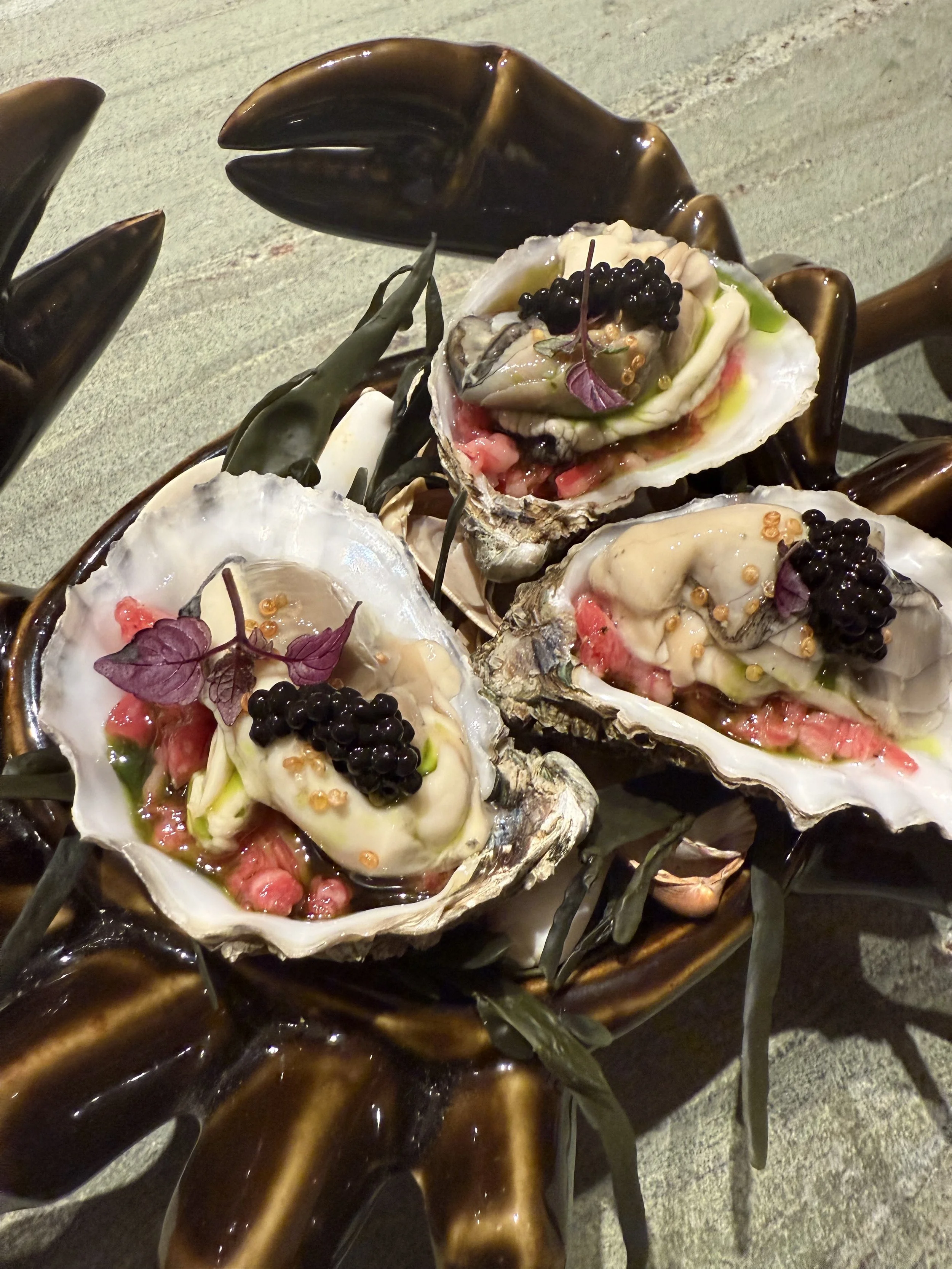 Oesters met garnalen, zwarte kaviaar, en bloemen op een bord. #chefvandenberghe , chef van den berghe , private dining, private chef aan huis