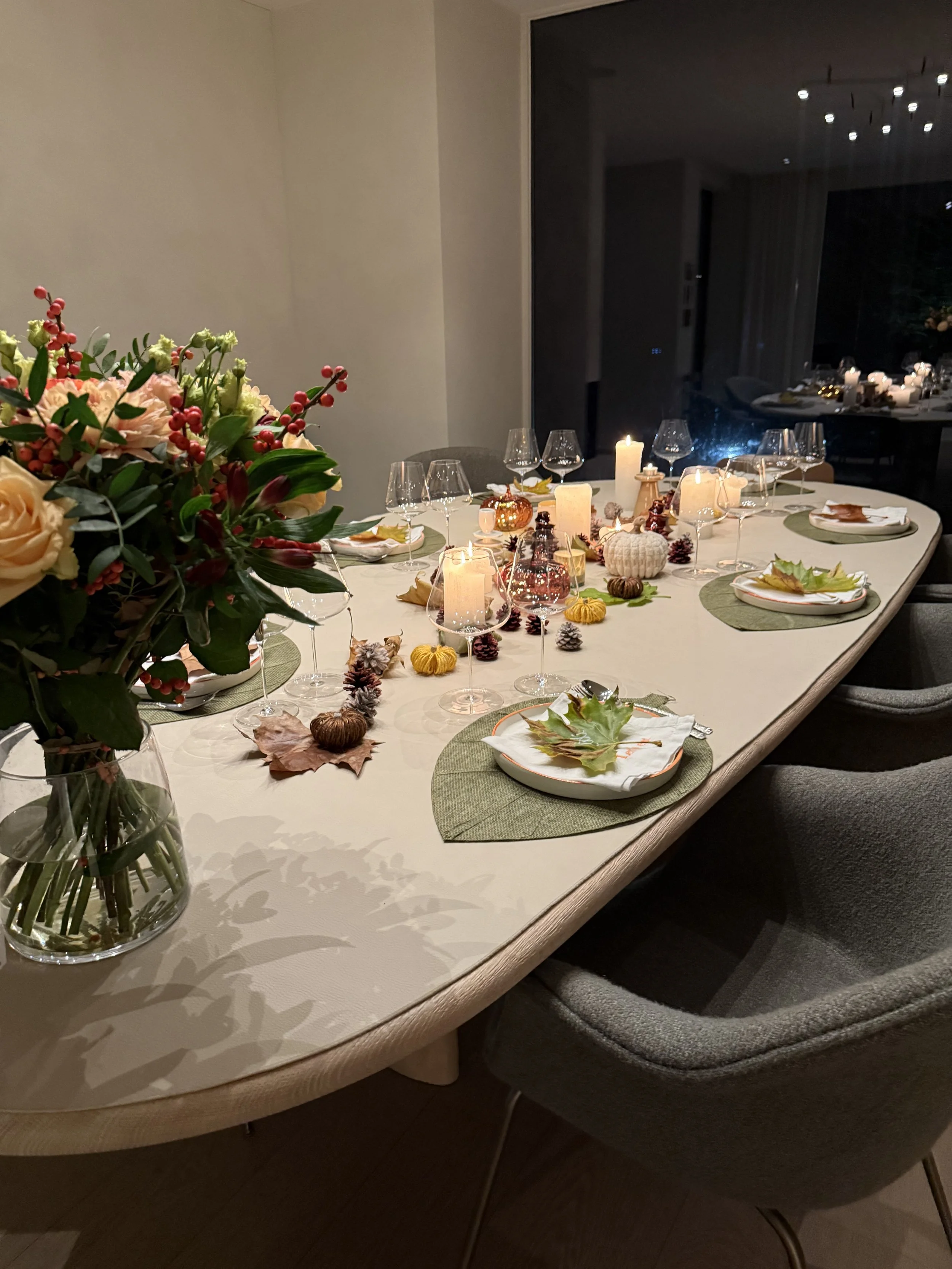 Een feestelijk gedekte dinertafel met kerstartikelen, such as kaarsen, herfstbladeren, pompoenen en kerstversiering, klaar voor een kerstbijeenkomst. #chefvandenberghe , chef van den berghe , private dining, private chef aan huis
