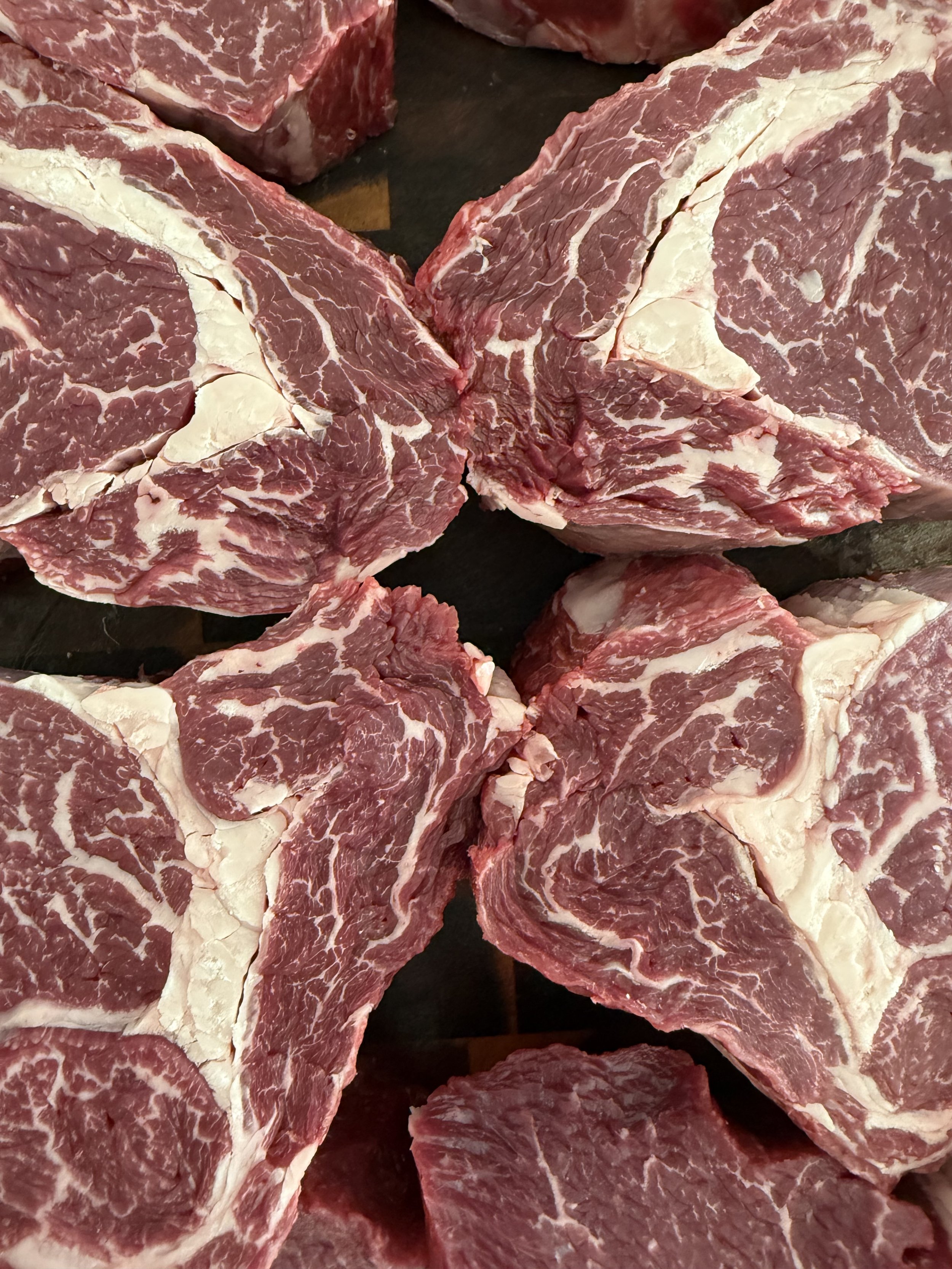 Verschillende stukken rauw vlees, waarschijnlijk rundvlees, op een donkere ondergrond. #chefvandenberghe , chef van den berghe , private dining, private chef aan huis