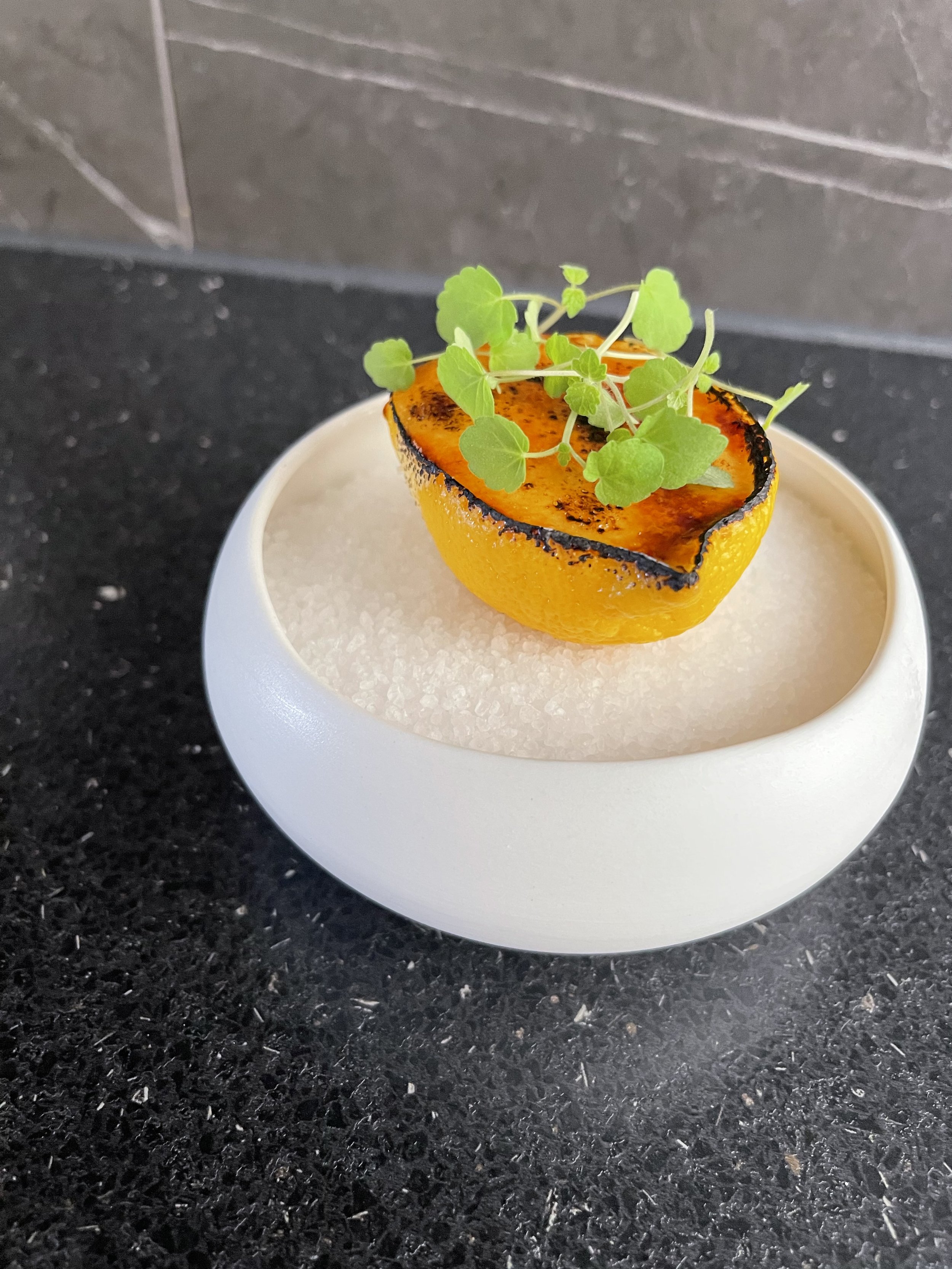 Geroosterde halve manderijn met microgreens op een witte kom.  #chefvandenberghe , chef van den berghe , private dining, private chef aan huis