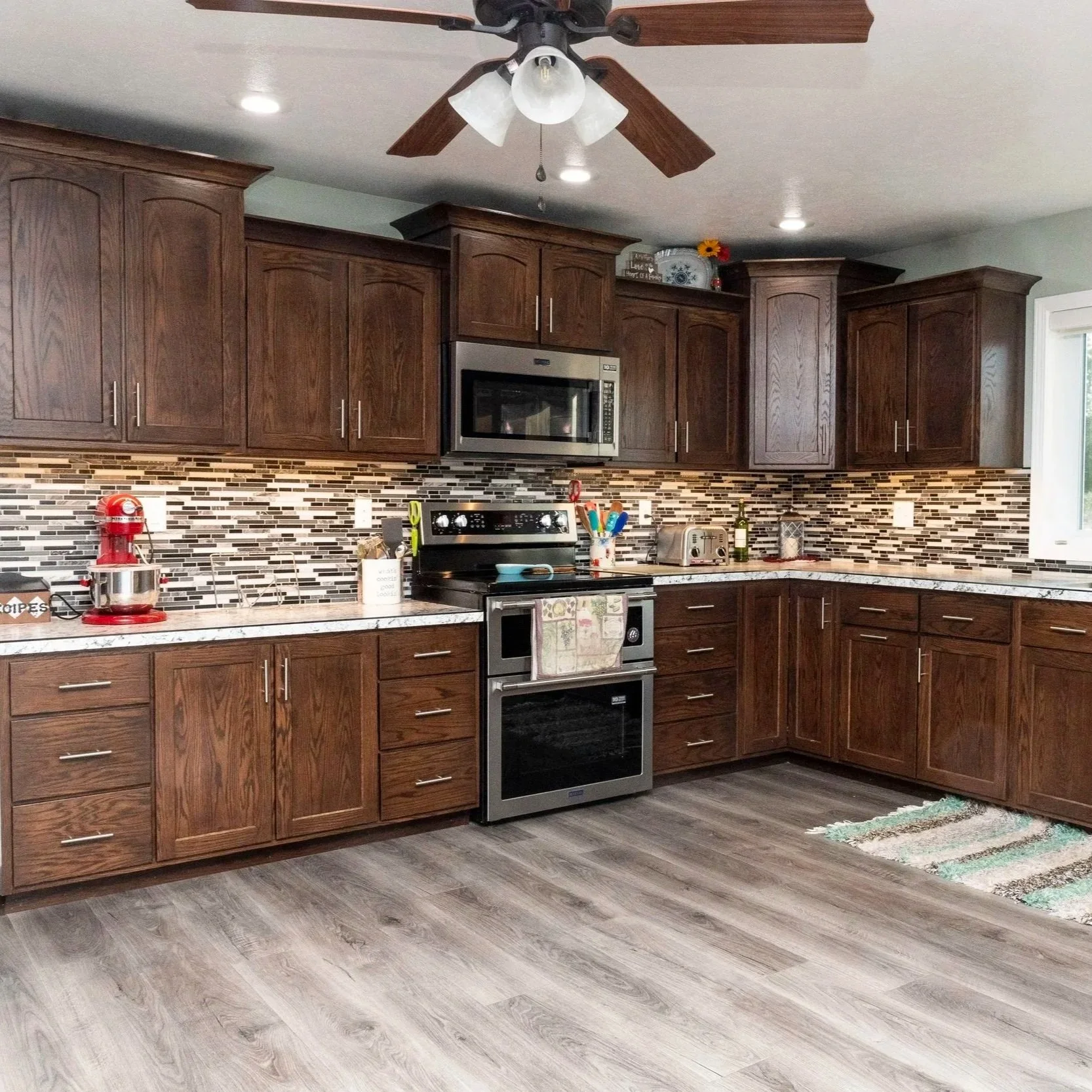 Dark Stained Wood Kitchen with Staggered Upper Cabinets & Large Pantry