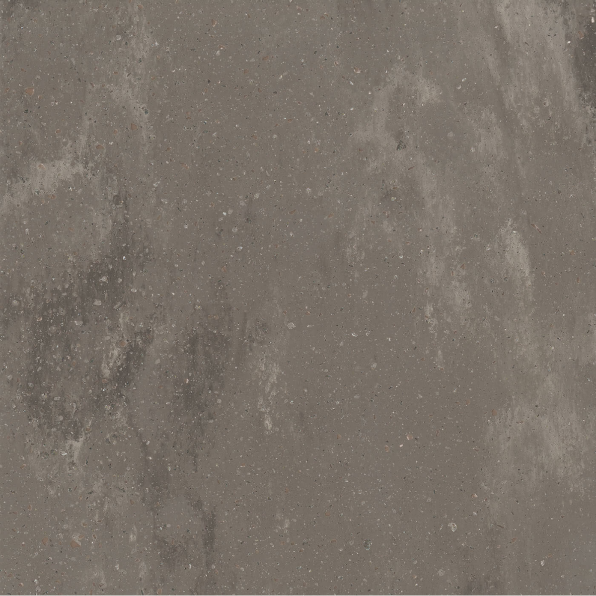 A close-up view of a gray solid surface countertop with small pebbles and patches of darker discoloration.