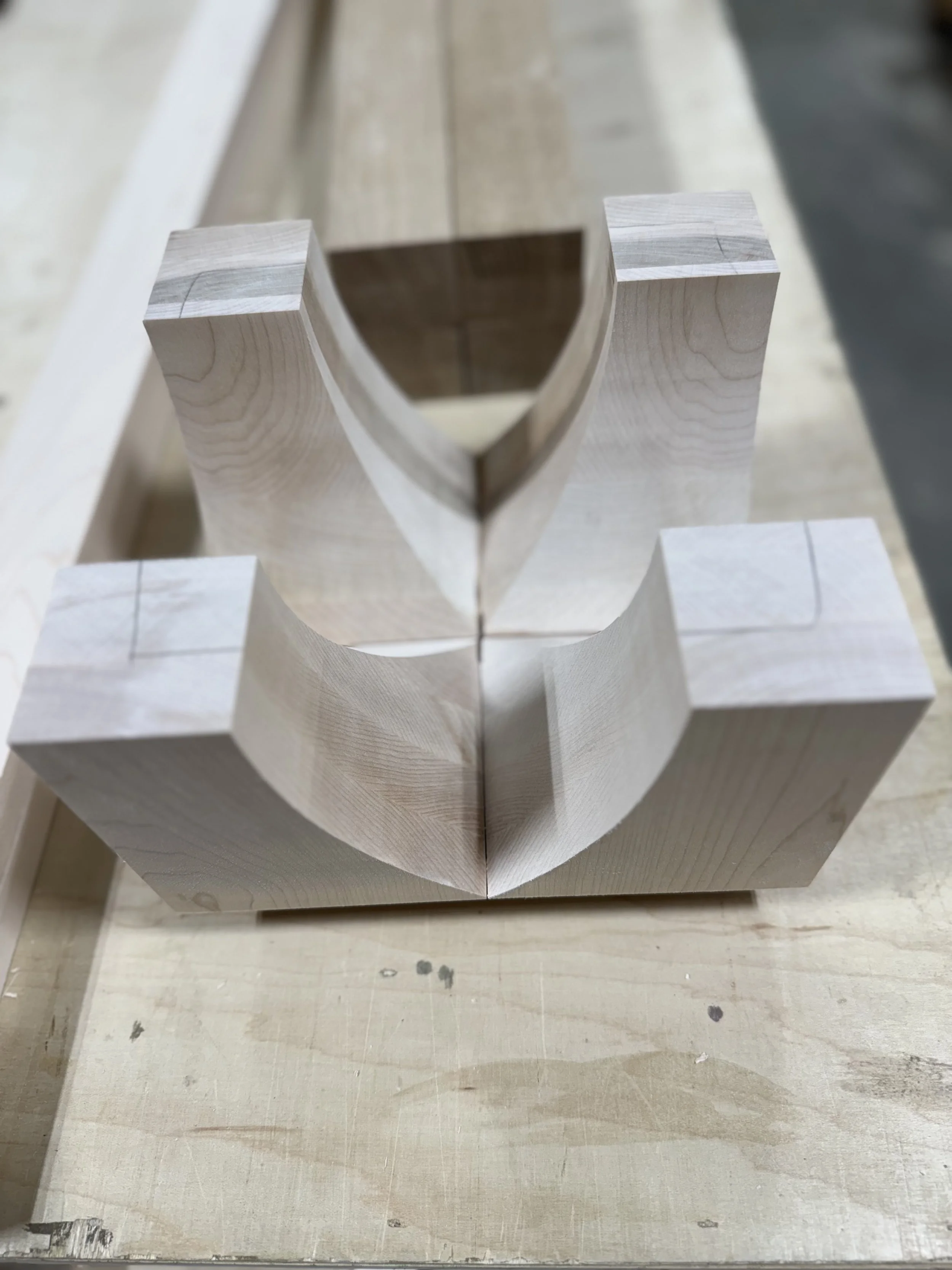 Stacked wooden blocks with curved cutouts, viewed from above.