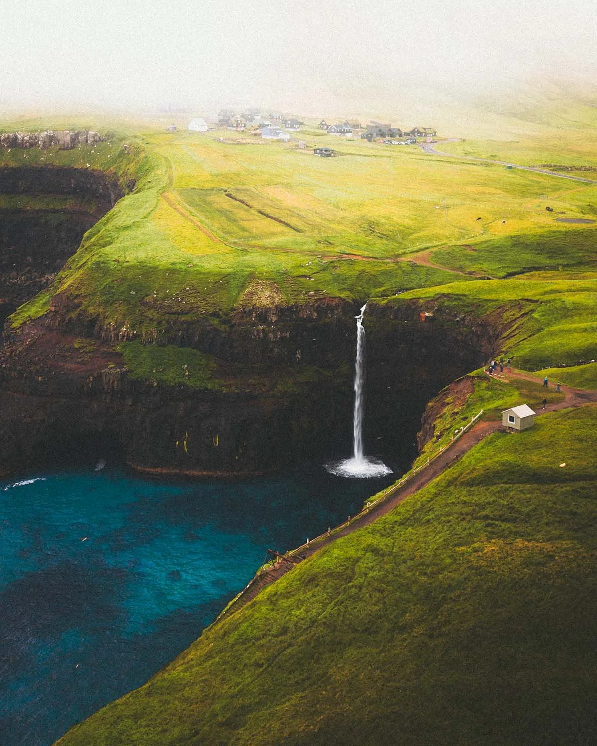Vue iconique de la cascade de Múlafossur se jetant directement dans l'océan Atlantique près du village de Gásadalur. Le paysage le plus célèbre des Îles Féroé capturé par Dimitri Weber.