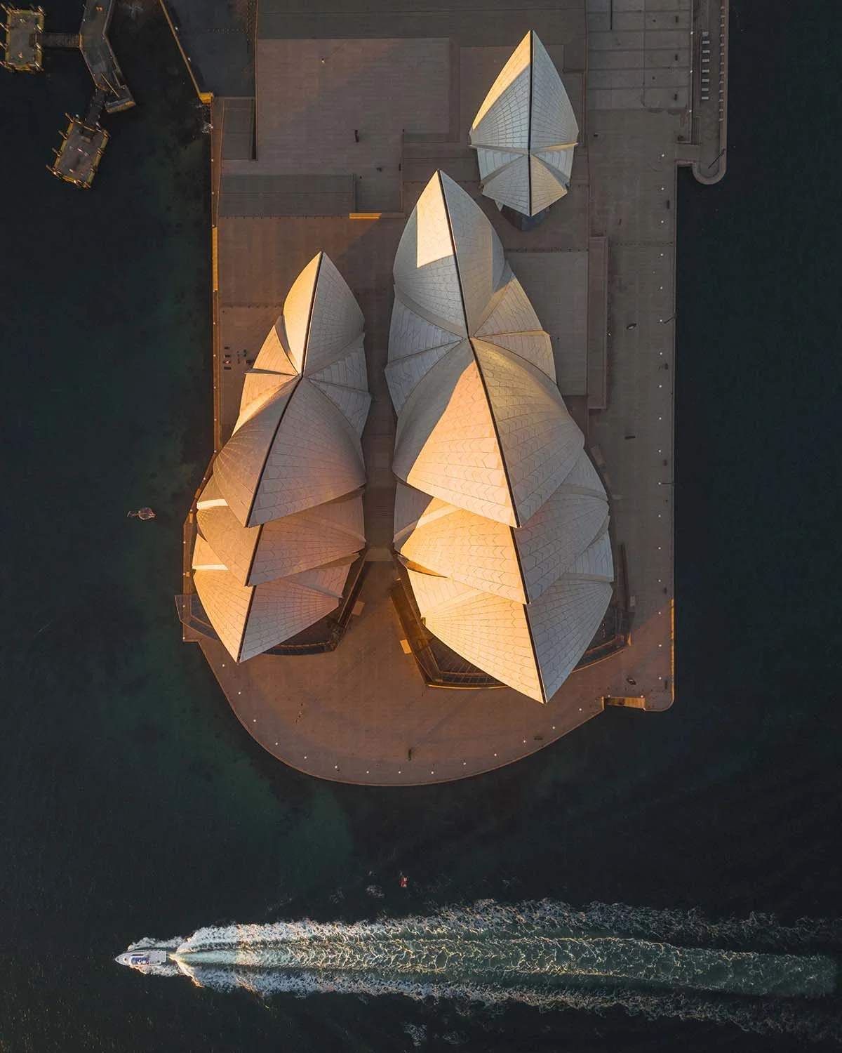 Vue graphique (top-down) inédite sur les célèbres "voiles" et les tuiles de céramique de l'Opéra de Sydney, mettant en valeur l'architecture de Jørn Utzon.