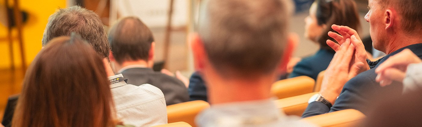 Vue de l'audience applaudissant lors d'un événement corporate. Capture de l'ambiance, de la réussite et des temps forts de votre convention d'entreprise par un photographe professionnel.