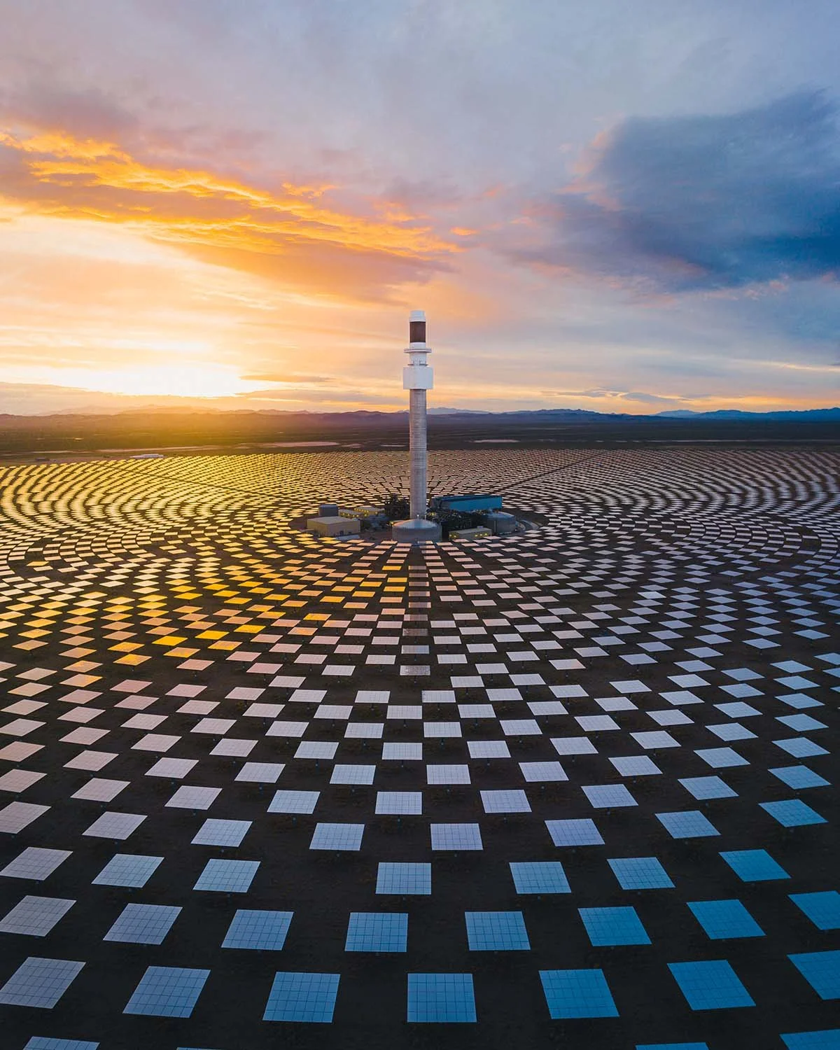 Centrale solaire thermodynamique Crescent Dunes Solar Energy Project Tonopah Nevada coucher soleil. Tour centrale sel fondu champ miroirs circulaires énergie verte désert USA technologie.