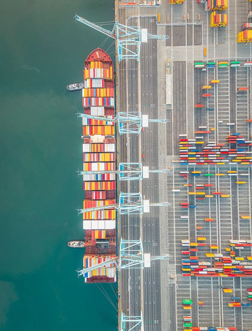 Impressionnante vue zénithale d'un navire porte-conteneurs à quai lors des opérations de chargement.