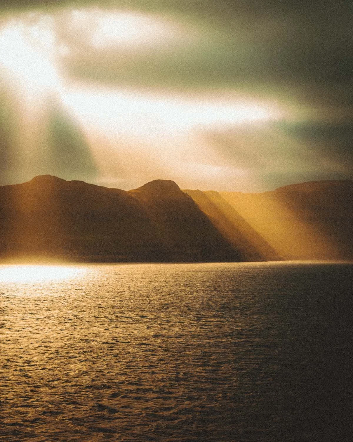 Lumière dorée du coucher de soleil se reflétant sur l'immensité de l'océan Atlantique Nord. Photographie de voyage prise depuis le ferry Smyril Line.