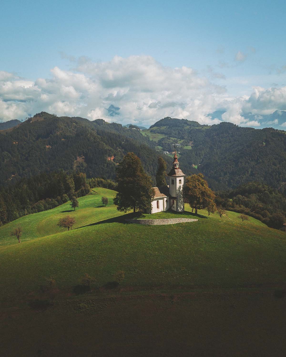 Sanctuaire perché. L'église Saint Thomas domine les vallons slovènes alors que les nuages accrochent les sommets.