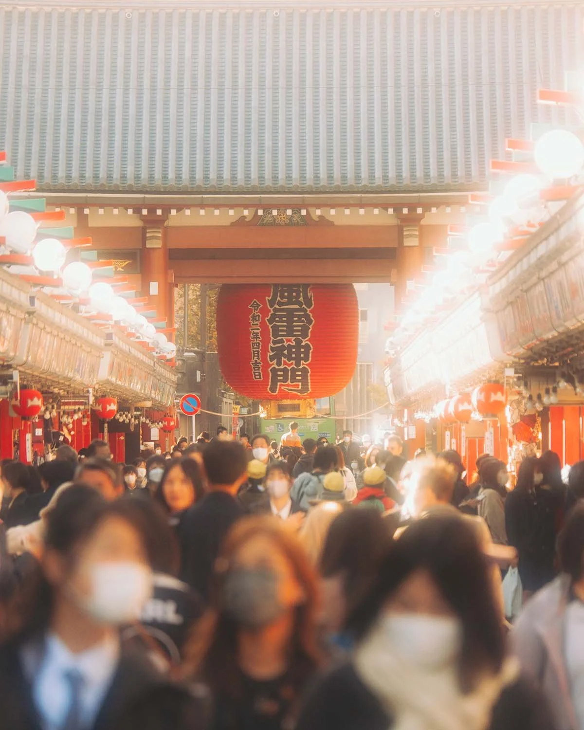 Photographie de rue foule touristes devant la porte Kaminarimon et la lanterne rouge géante du temple Senso-ji à Asakusa Tokyo. Ambiance urbaine Japon culture bouddhiste rue commerçante Nakamise dori et architecture traditionnelle.