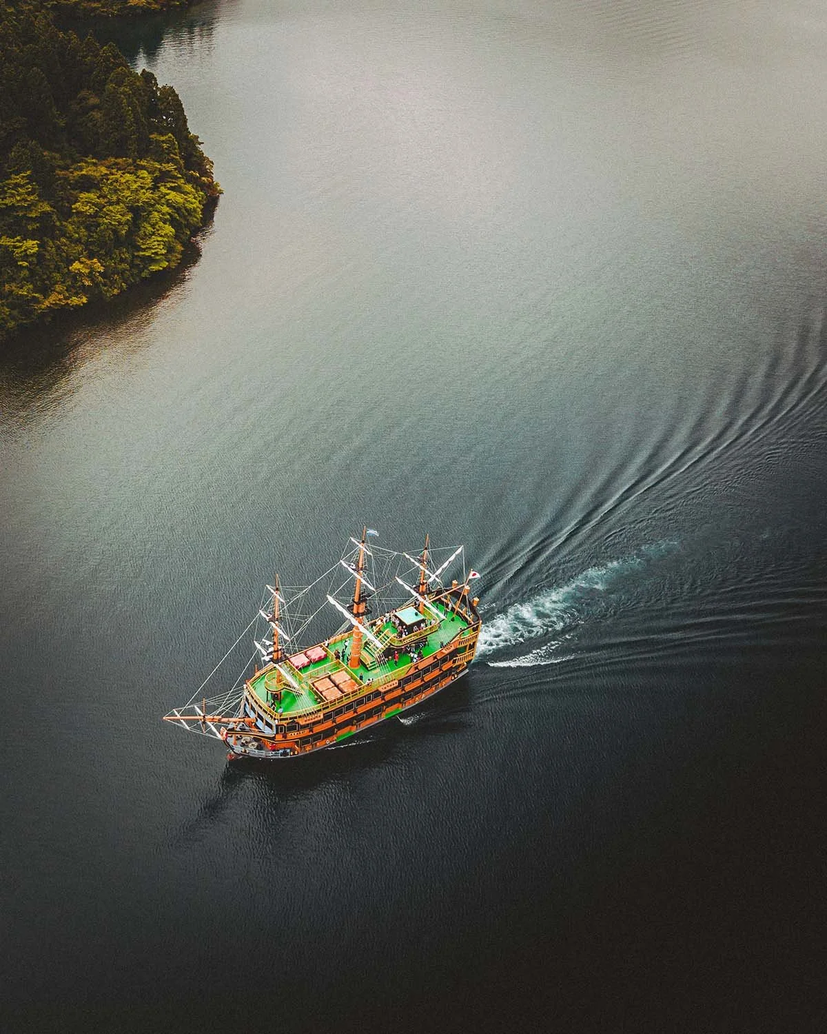 Sur les eaux sombres du Lac Ashi. Le célèbre bateau de Hakone navigue au pied des montagnes.
