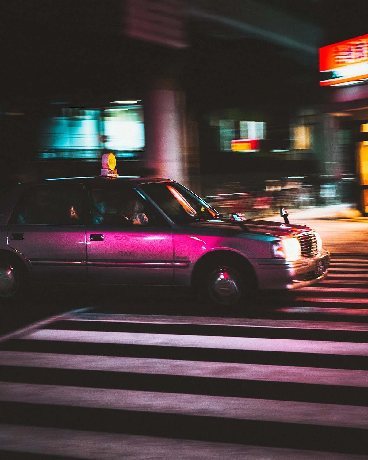 L'énergie cinétique de la capitale. Un taxi traverse la nuit tokyoïte éclairée par les néons.