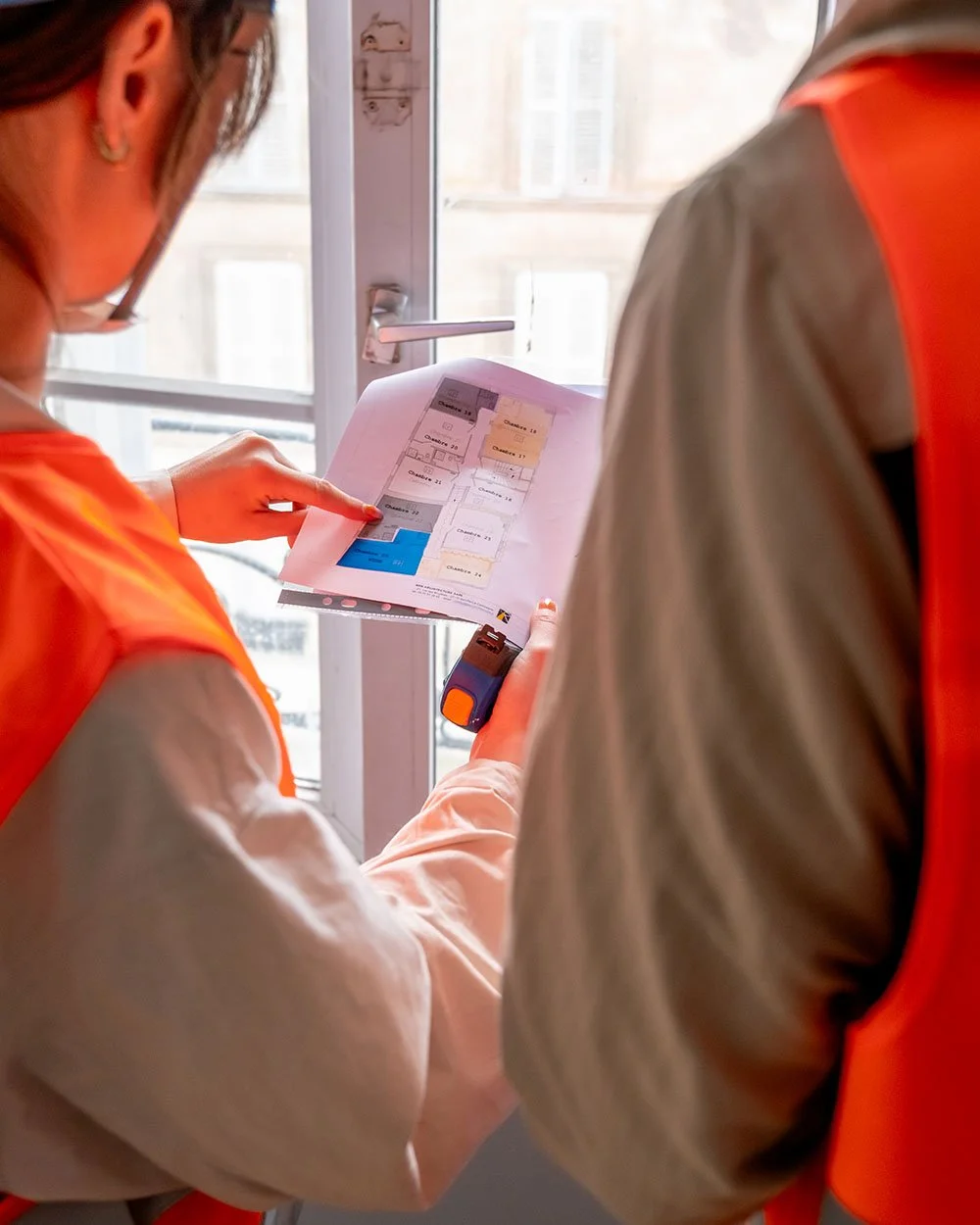 Suivi de chantier BTP à Paris : équipe consultant les plans et prenant des mesures lors d'une rénovation d'intérieur.