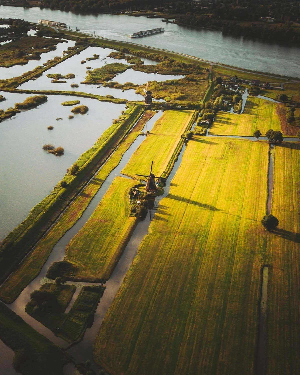 Patrimoine du vent. Les moulins historiques de Kinderdijk alignés le long des canaux hollandais au coucher du soleil.