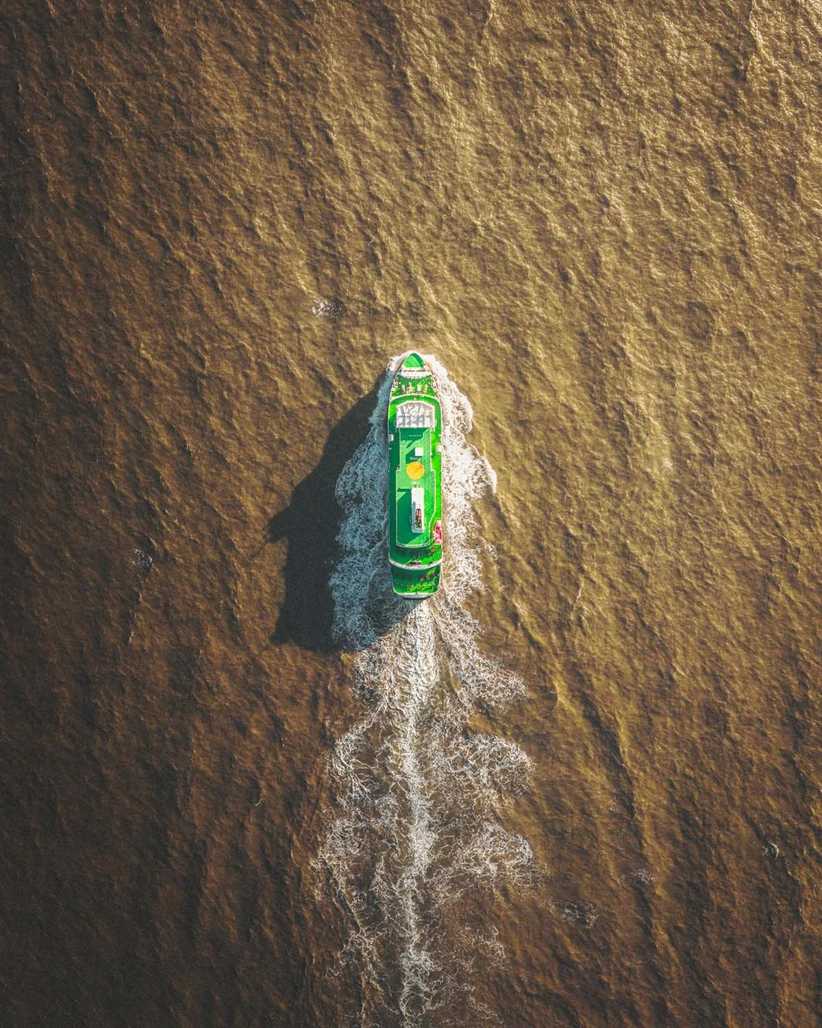 Vue zénithale graphique du ferry Herjólfur naviguant vers les Îles Vestmann dans les eaux profondes de l'Atlantique Nord.