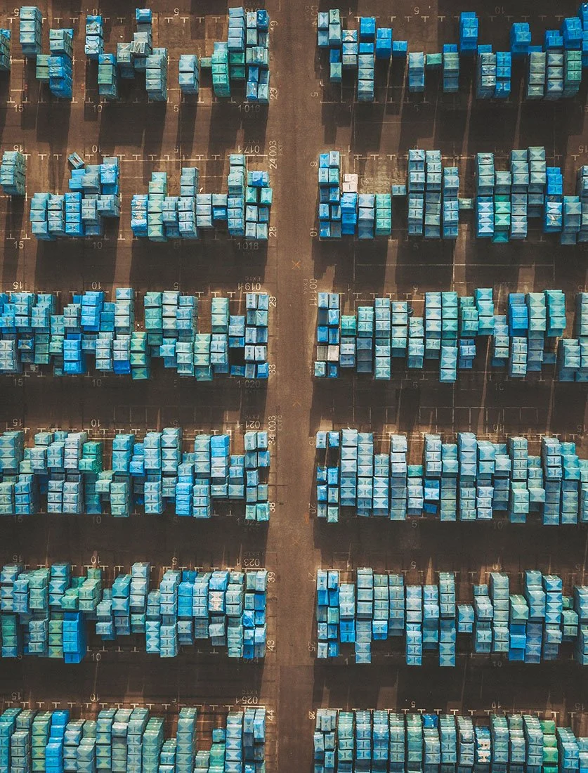 Vue aérienne graphique et structurée d'une zone de stockage de conteneurs. Photographie industrielle et logistique.