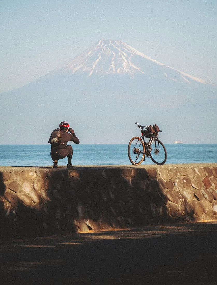 Cycliste photographiant le Mont Fuji lors d'un voyage au Japon. Une image mêlant sport, aventure et paysage emblématique.