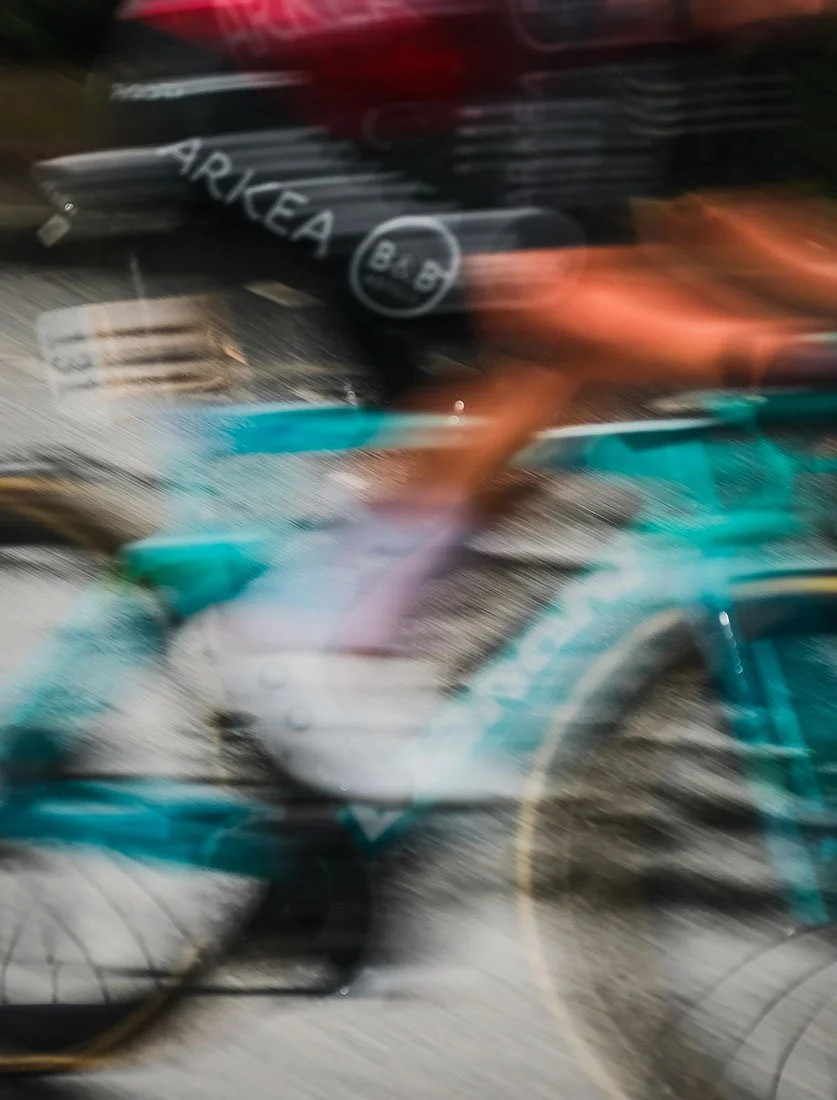 Action intense d'un cycliste en plein effort capturée avec un effet de flou de mouvement (filé) pour accentuer la dynamique de la course.