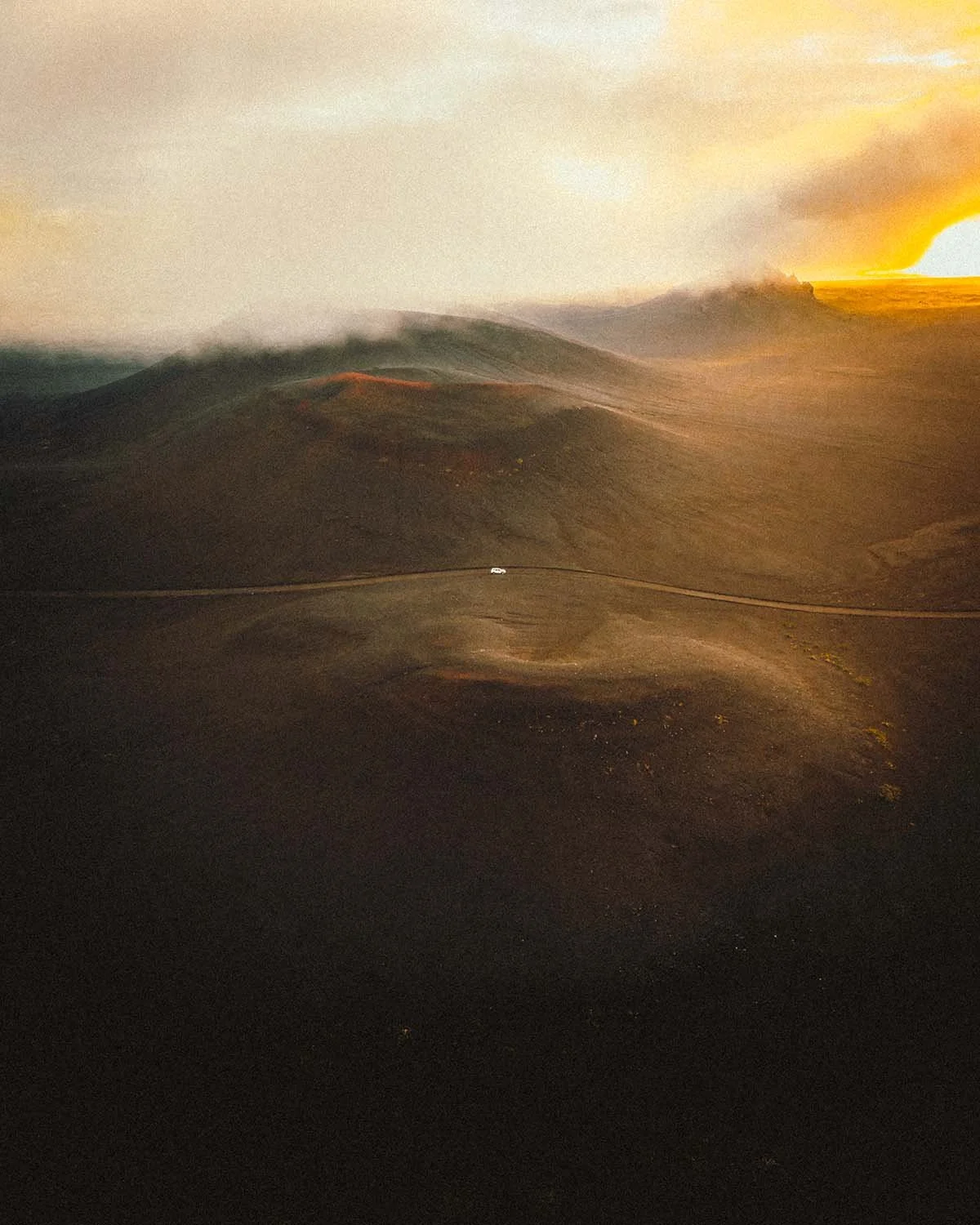 Panorama aérien spectaculaire capturant la grandeur de trois volcans éteints alignés dans le désert noir des Hautes Terres islandaises. Photo Dimitri Weber.